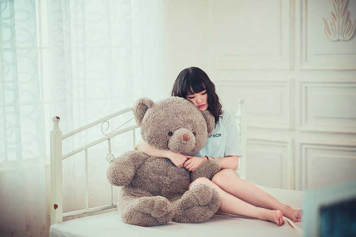 A girl holding on to a teddy bear and missing her better half-Illustration of 'When you miss him' 